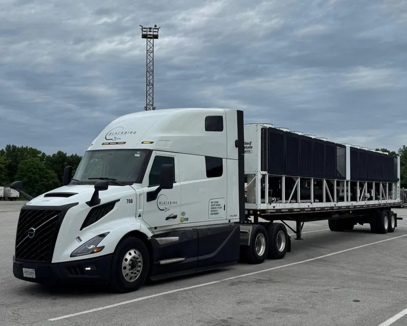 White Blackbird sleeper tractor, unit 708, hauling a loaded flatbed trailer